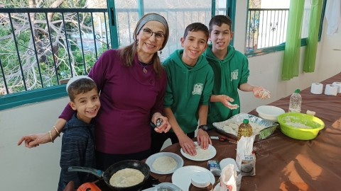 תמונה מתוך ההתנדבות. אישה עם שלושה ילדים מכינים לאכול.jpg