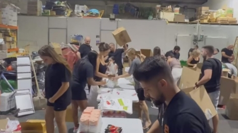 תמונה  של  תושבים אורזים את סלי המזון שהכינו.jpg