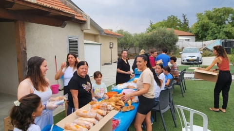 תמונה של  תושבים אורזים את סלי המזון שהכינו.jpg