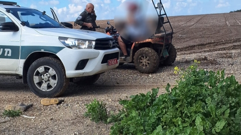 ניידת של מגב לידה שוטר מגב מדבר בטלפון ולידו טרקטורון.jpeg