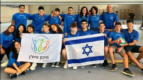 תמונה של ילדים לובשים חולצות כחולות ומחזיקים דגל ישראל ודגל של תיכון איתן.jpg