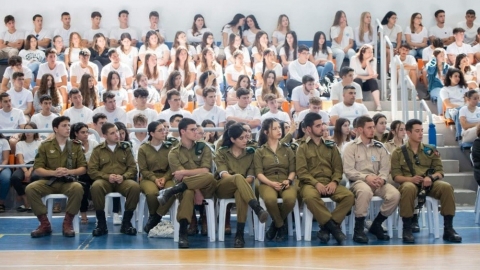 ילדים וחיילים יושבים בתוך אולם ספורט.jpg