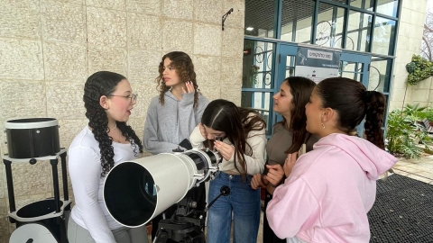 ילדים עומדים סביב טלסקופ ענק.jpeg