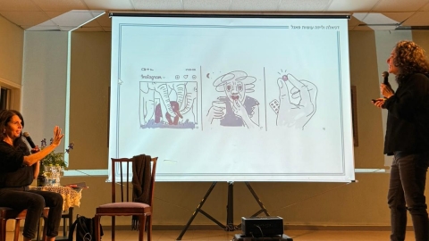 שתי נשים עומדות על במה עם מיקרופונים. יש מצגת ברקע.jpg