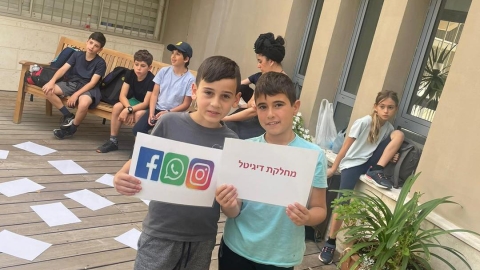 ילדים עומדים ומחזיקים דפים.jpg