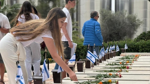 אנשים מניחים על קברים פרחים.jpg