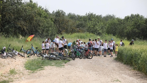 אנשים וילדים בעצירת התרעננות ליד האופניים שלהם.jpg