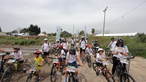 אנשים וילדים עם קסדות רוכבים על אופניים.jpg