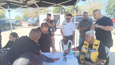 אנשי הצלה וכוחות הביטחון מתכנסים סביב מפה.jpg