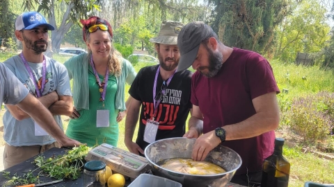 אנשים עומדים סביב קערה.jpg