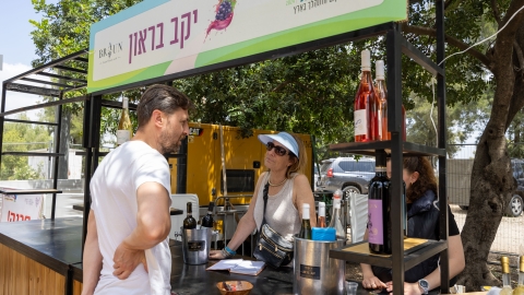 אנשים עומדים ליד דוכן יין.jpg
