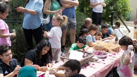 אנשים יושבים מסביב לשולחן נמוך ומכינים יצירות.jpg