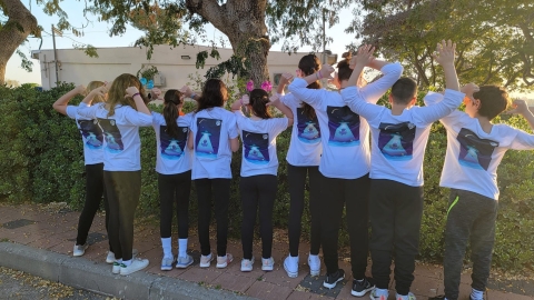 תמונה של ילדים עומדים עם גב למצלמה בחולצות לבנות.jpg