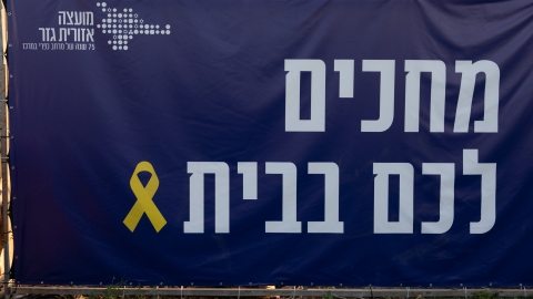 שלט עם סימן החטופים ועליו כתוב מחכים לכם בבית.jpg