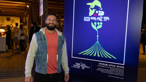 איש עומד ליד תמונה שכתוב עליה כי האדם עץ.jpg