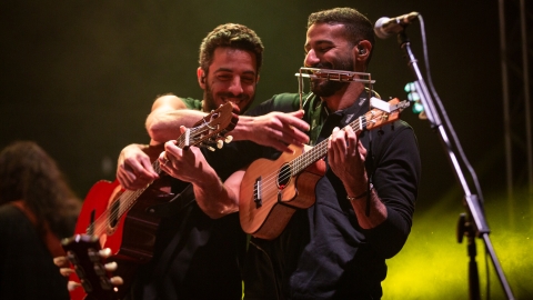 שני נגני גיטרה מתחבקים על הבמה.jpg