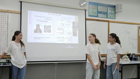 שלוש  בנות עומדות ליד מסך ומסבירות על הפרוייקט שלהן.jpg