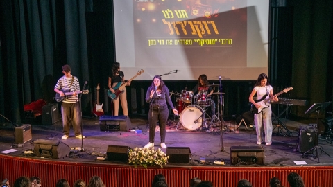 אנשים מניגינים על במה ואישה שרה.jpg