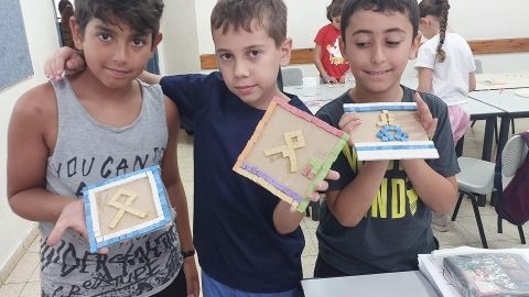 ילדים מחזיקים יצירות מפסיפס.jpg