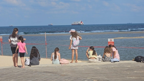 ילדים יושבים על חוף הים.jpg