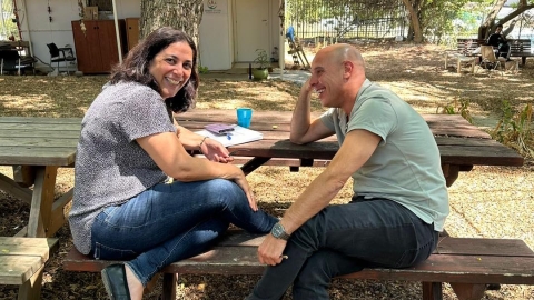 אנשים יושבים על ספספל מעץ בטבע.jpg