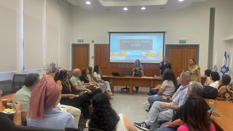 אנשים יושבים ומולם יש מצגת  שכתוב עליה פתיחת שנת הלימודים תשפה.jpg