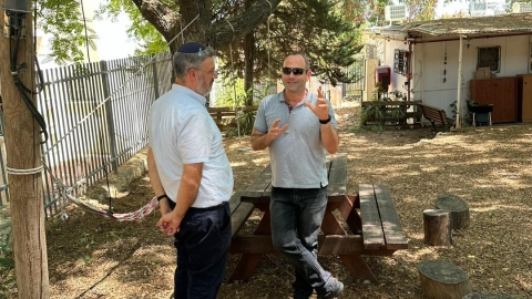 אנשים עומדים ליד ספספל מעץ בטבע.jpg