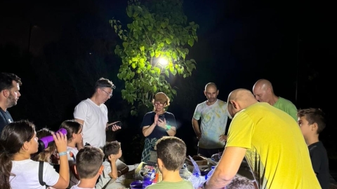 אנשים עומדים סביב שולחן עם תאורה בצד.jpg