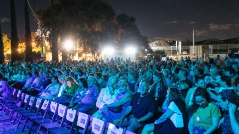 אנשים יושבים על כיסאות וצופים בהופעה.jpg