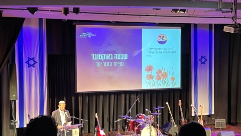 איש עומד על במה ונואם.jpg