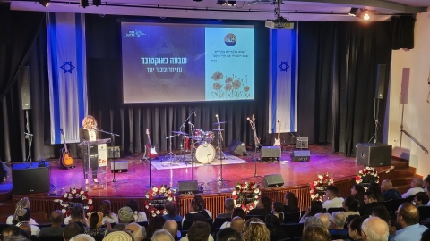 אישה עומדת על במה ליד פודיום.jpg