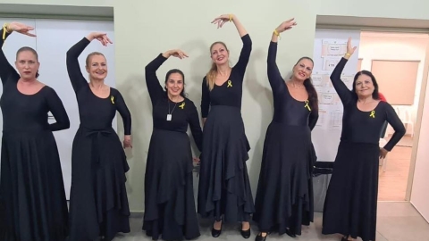 בנות הלהקה לובשות שמלות שחורות ועונדות את סיכת החטופים.jpg