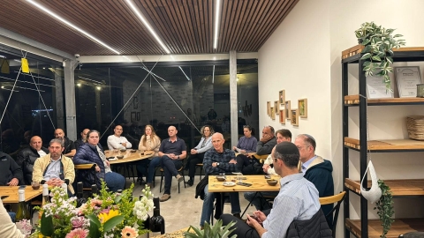 אנשים יושבים על כיסאות סביב שולחן.jpg