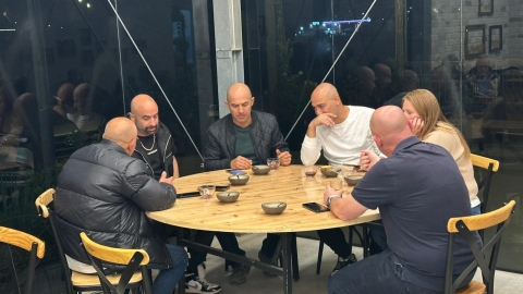 אנשים יושבים סביב שולחן עגול מעץ.jpg