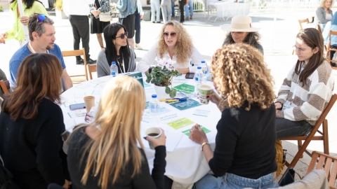 אנשים  יושבים סביב  שולחן עם  מפה  לבנה.jpg
