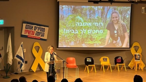 רותם ידלין בערב בו הגיעה מירב לשם גונן למועצה. מאחוריה על המבה כיסאות צהובים עם סמלי החטופים עליהם.j