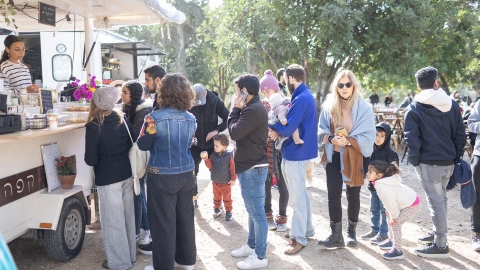 אנשים עומדים ליד דוכן.jpg