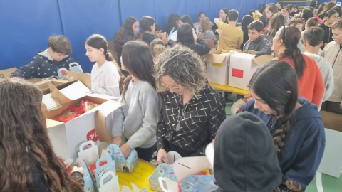 רותם ידלין ראשת המועצה אורזת משלוחי מנות יחד עם התלמידים.jpeg
