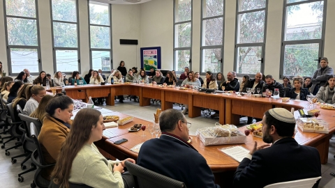 עובדי המליאה יושבים סביב שולחן בחדר הישיבות.jpeg