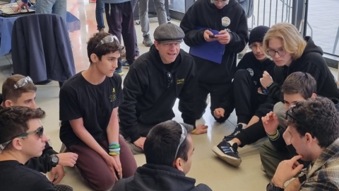 תלמידים מהנבחרת יושבים במעגל באולם התחרות.jpeg