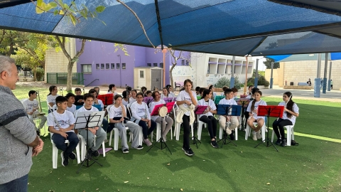 תלמידים בהופעה מוסיקלית מול האנשים במפגש.jpeg