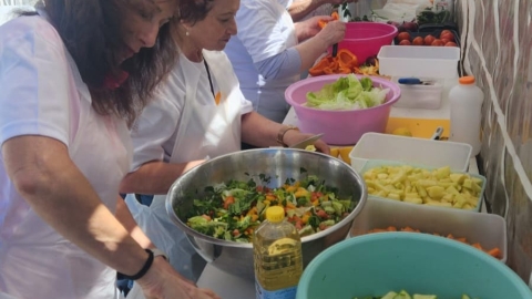 הוותיקים והוותיקות שהגיעו להתנדב בתחנת עמיחי מכינים אוכל.jpg