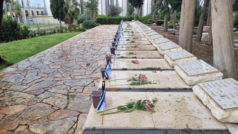 ורדים מונחים על קברי הנופלים בבית העלמין בקיבוץ חולדה.jpg