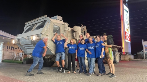 מתנדבים בעמי חי מצולמים ליד רכב צבאי.jpg