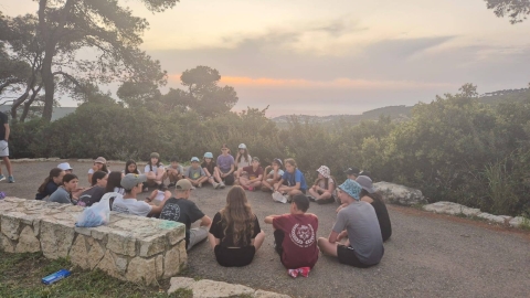 חניכים יושבים במעגל בפעילות שמעוברת במהלך טיול.jpg