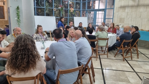 המשתתפים בערב יושבים בשולחנות עגולים.jpg