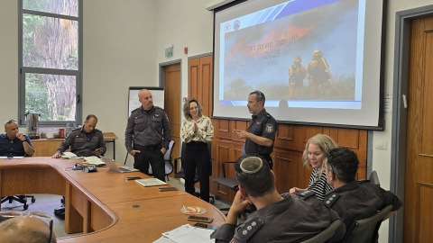 מתנדב יחידת הכיבוי מהמועצה עדי לב יהושע מדבר בכנס.jpg