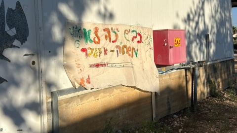 שלט שנתלה על קיר עליו כתוב כביש זה לא משחק.jpeg