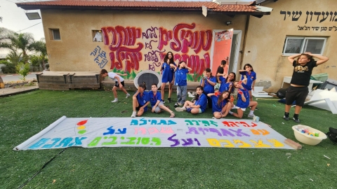 חניכים מכינים שלט בו כתוב נהיגה זהירה מתחילה עם אחריות שמרו על עצמיכם ועל הסובבים.jpeg