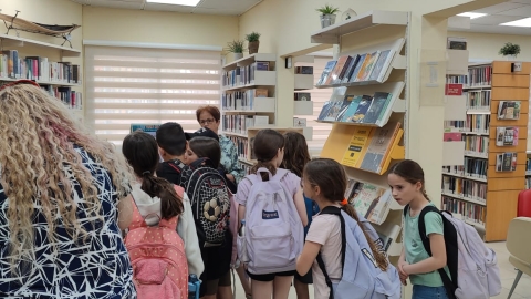 תלמידים בספרייה אזורית גזר עם מנהלת הספרייה מימי אבקסיס.jpeg